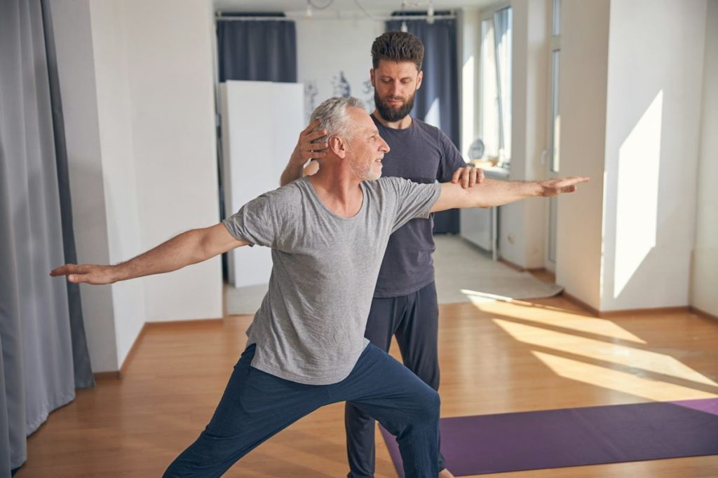 Un coach de yoga explique une posture à son élève.