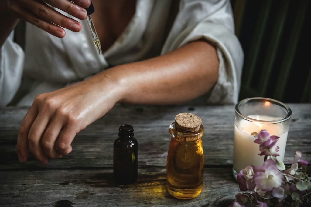 Une dame enduit son bras d'huiles essentielles dans une séance de bien-être.