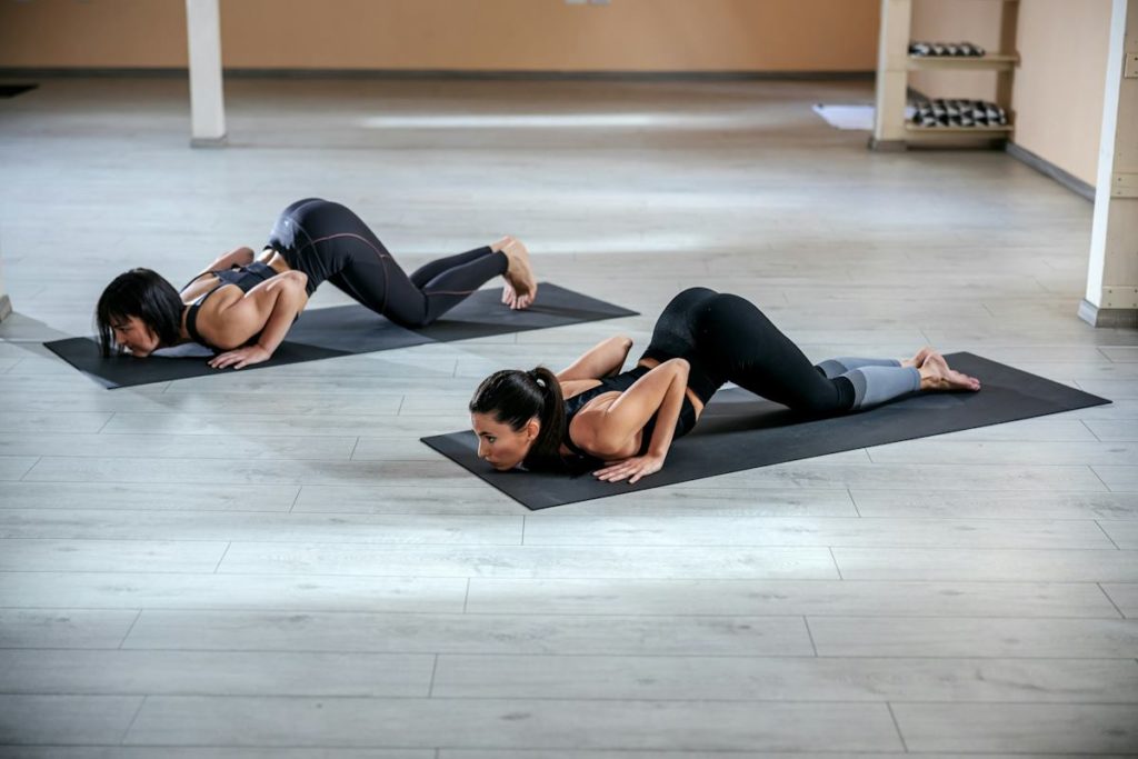 Des femmes remontent d'une pompe au yoga sur un tapis.