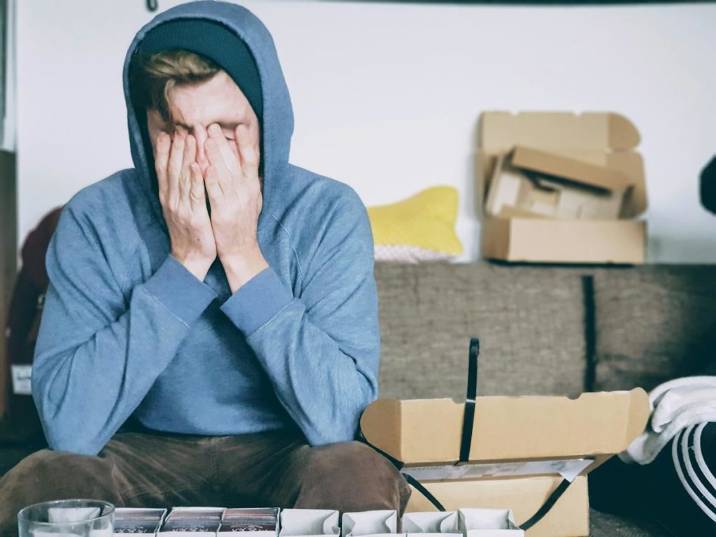 Un garçon avec un sweat à capuche semble désemparé sur une chaise.