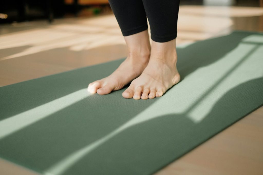 Deux pieds posés au sol sur un tapis de gym.