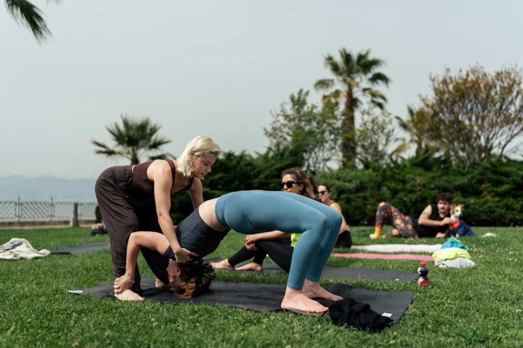 Un groupe de personnes font du yoga avec une coach.