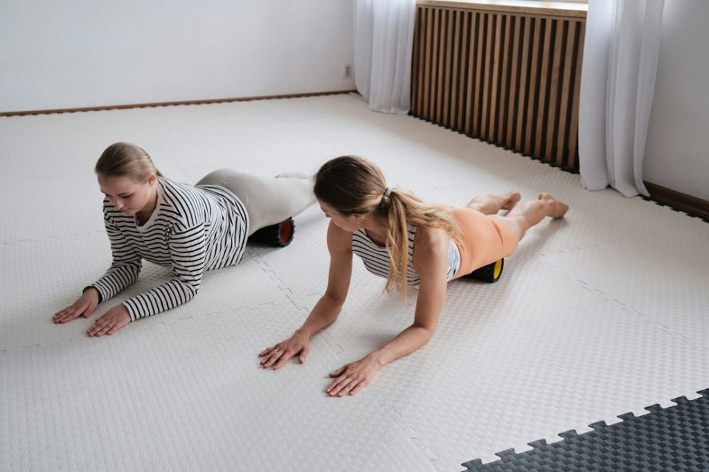 Des pratiquantes de yoga s'entraînent dans une pièce blanche lumineuse.