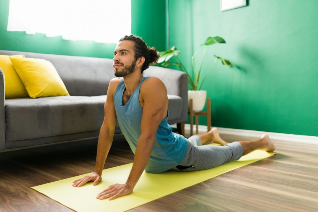 Un pratiquant de yoga effectue une posture dans son salon.