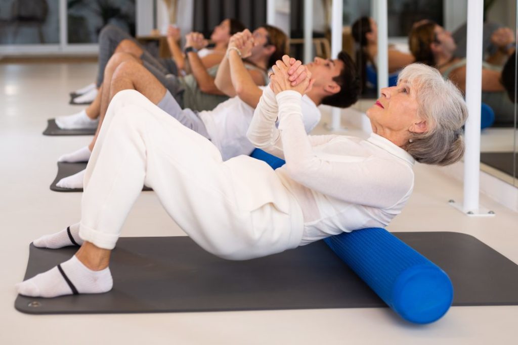 Une femme en train de faire des exercices de Pilates au sol.