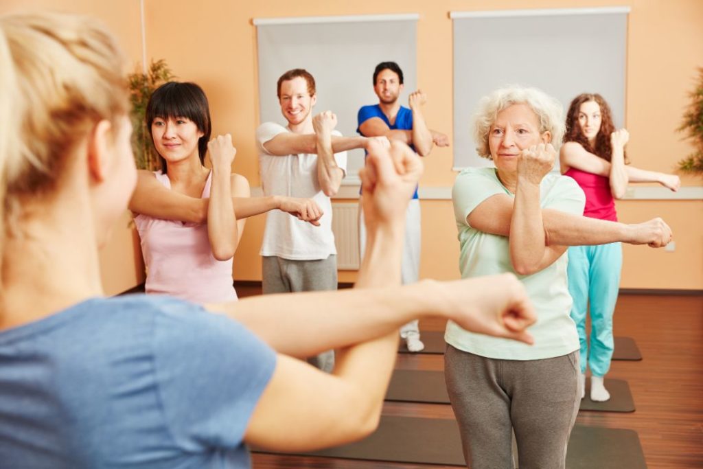 Vue d'un groupe de pratiquants d'une salle de remise en forme devant leur professeur.