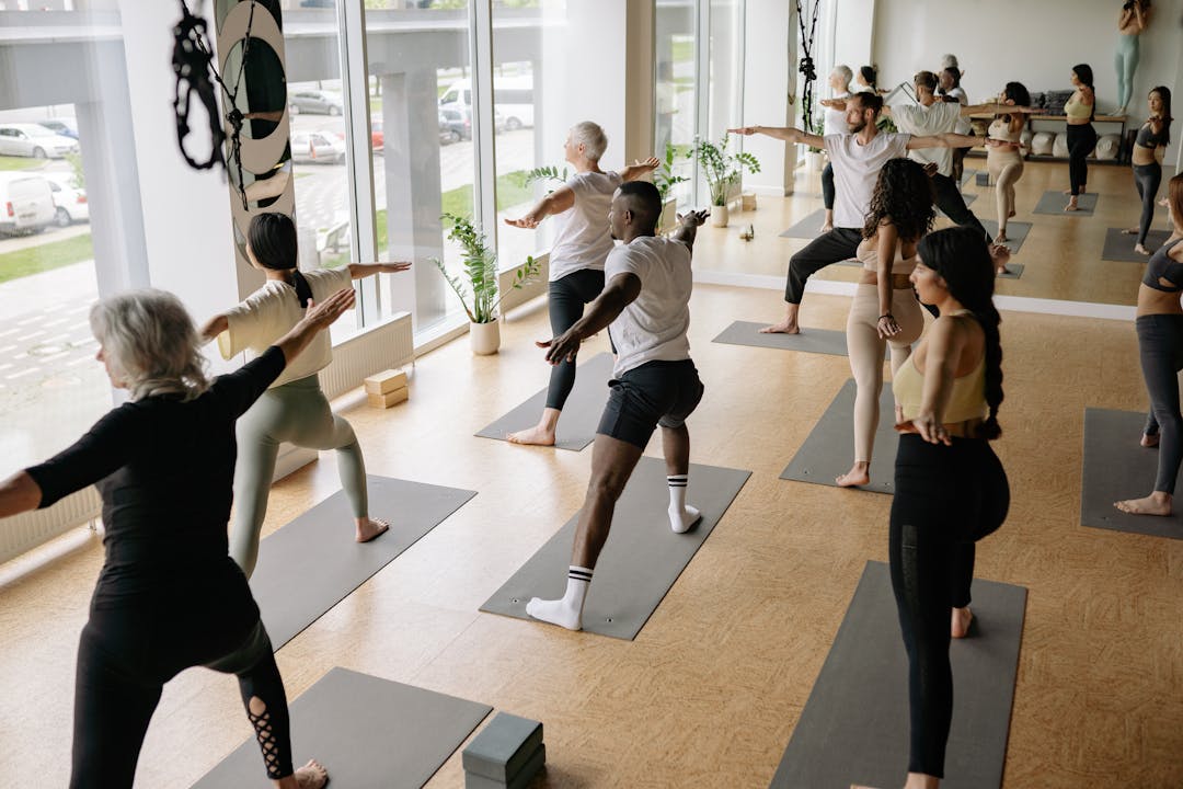 Un groupe de personnes en train de s'étirer debout, lors d'une séance de yoga.