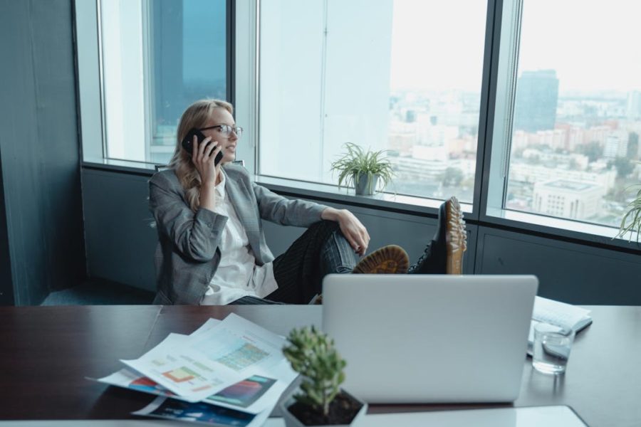 Une employée téléphone devant l'ordinateur de façon très décontractée.