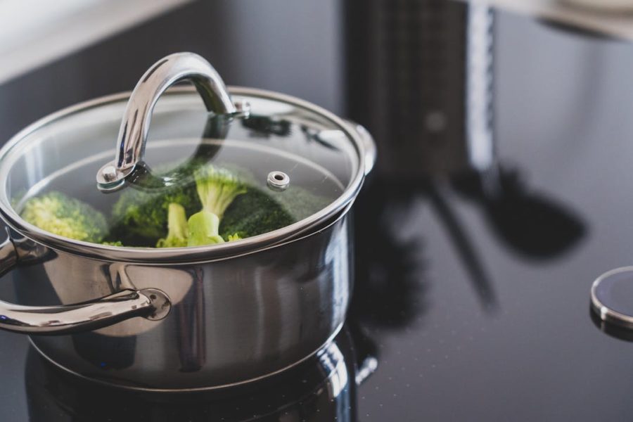 Vue rapprochée d'un fait-tout avec des légumes verts cuits à la vapeur.