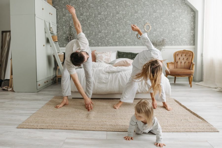 Un père et une mère font des étirements avec leur enfant devant.